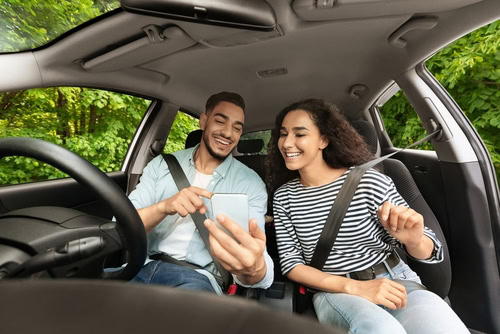 duas pessoas, um homem e uma mulher, viajando de carro, a fim de falar sobre o ride sharing.