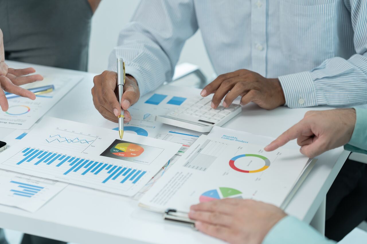 Profissionais analisando gráficos para entender a viabilidade da antecipação de recebíveis.