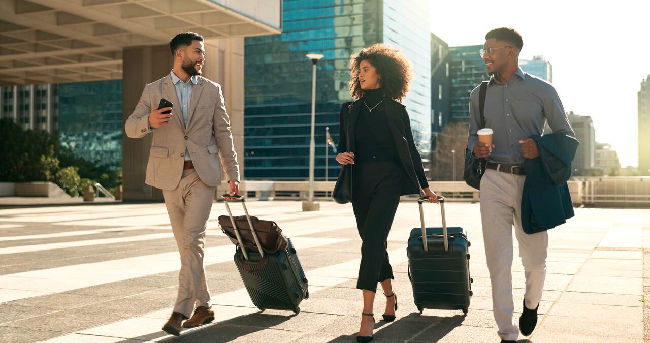 Três colaboradores andando com suas malas em meio a um feriado no sábado.