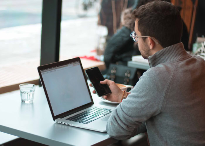 Funcionário trabalhando no seu notebook avaliando a gestão de reembolso de despesas corporativas.