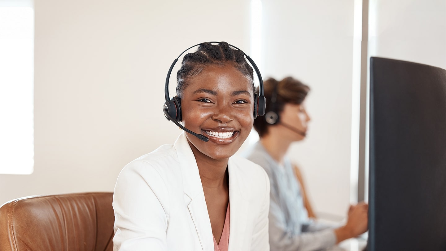 Consulta de viagens sorrindo para ilustrar os benefícios de uma agência de viagens corporativas.