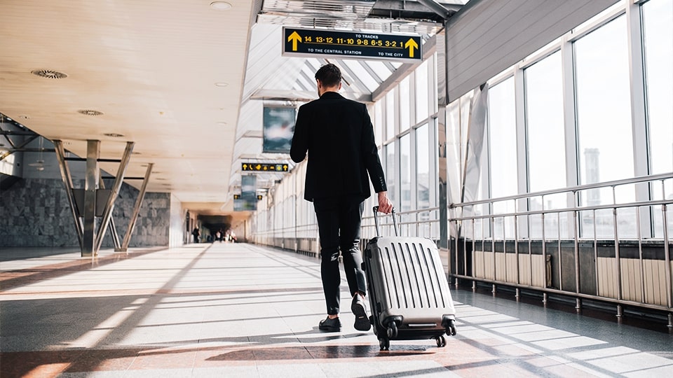 Profissional se preparando para uma viagem corporativa após a empresa comprar passagem aérea com CNPJ.