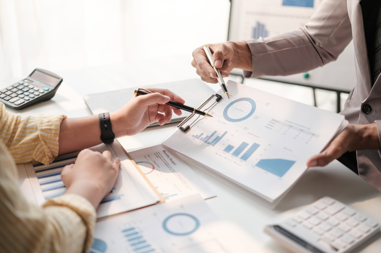 mãos analisando gráficos financeiros para analisar a quebra de caixa,