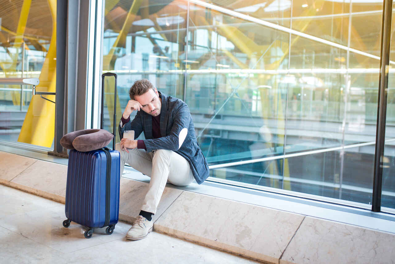 Viajante aguardando no aeroporto enquanto lida com os efeitos do jet lag em viagens corporativas.
