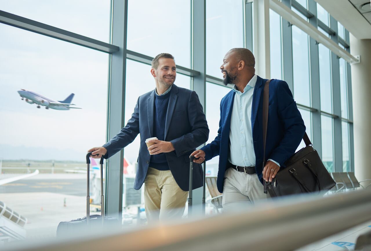 Dois homens em um aeroporto se preparando para uma viagem a trabalho.