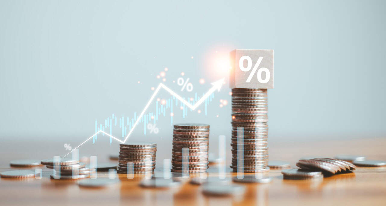 Gráfico de crescimento acima de uma pilha de moedas para falar sobre Alavancagem financeira.