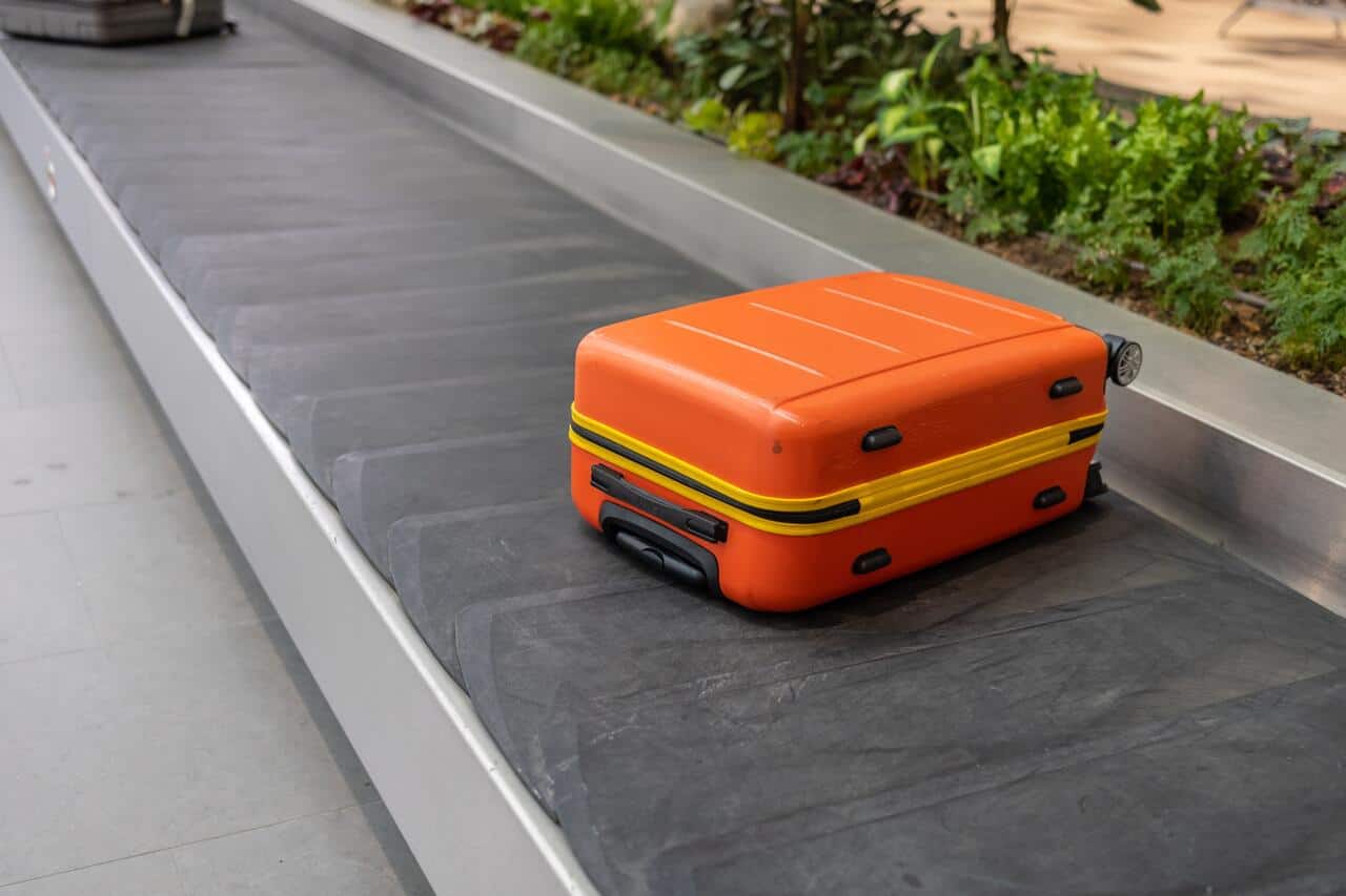 mala extraviada laranja na esteira de um aeroporto.