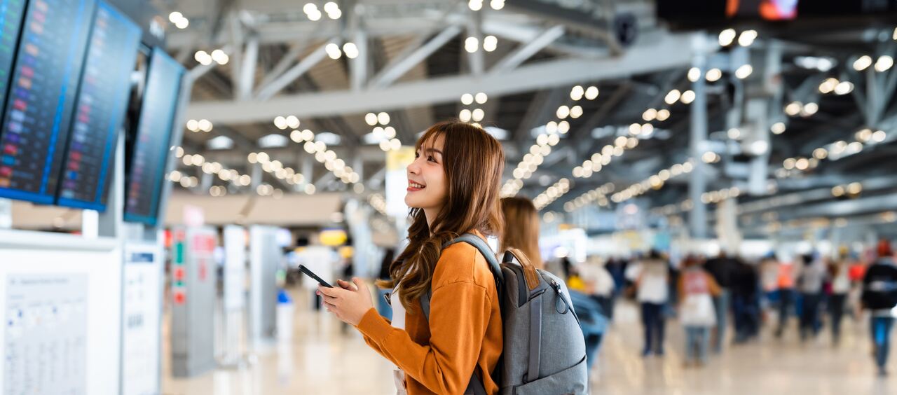 mulher asiática no aeroporto prestes a embarcar para sua viagem, a fim de falarmos sobre a importância do visto para o Japão.