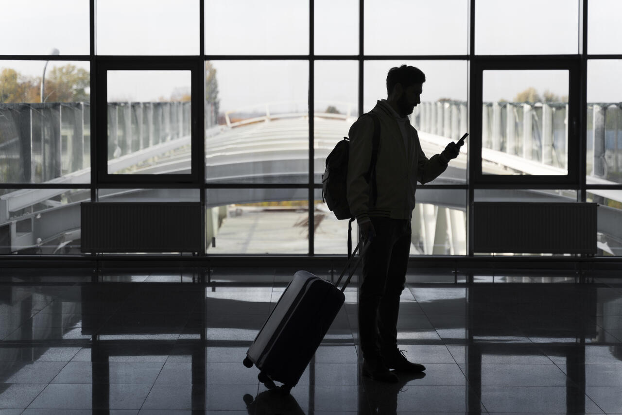 homem no aeroporto fazendo o seu check-in antecipado.
