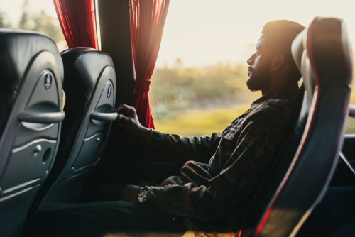 Profissional viajando de ônibus para um compromisso corporativo, a fim de discutir sobre os tipos de ônibus.