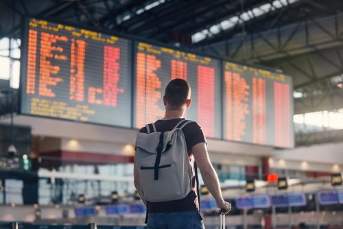 Passageiro corporativo no aeroporto precisando lidar com um voo atrasado.