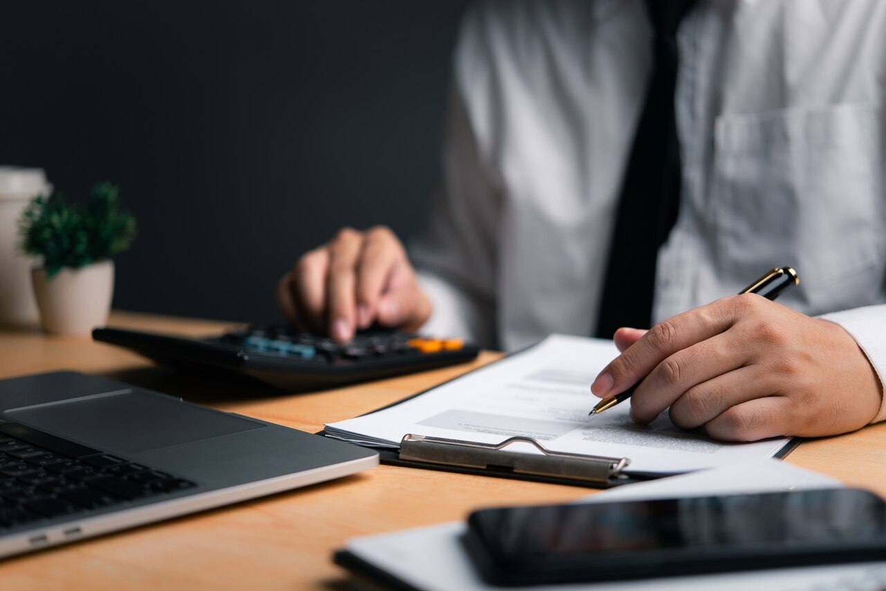 Profissional trabalhando no seu escritório com uma calculadora, a fim de entender o que é NCG.