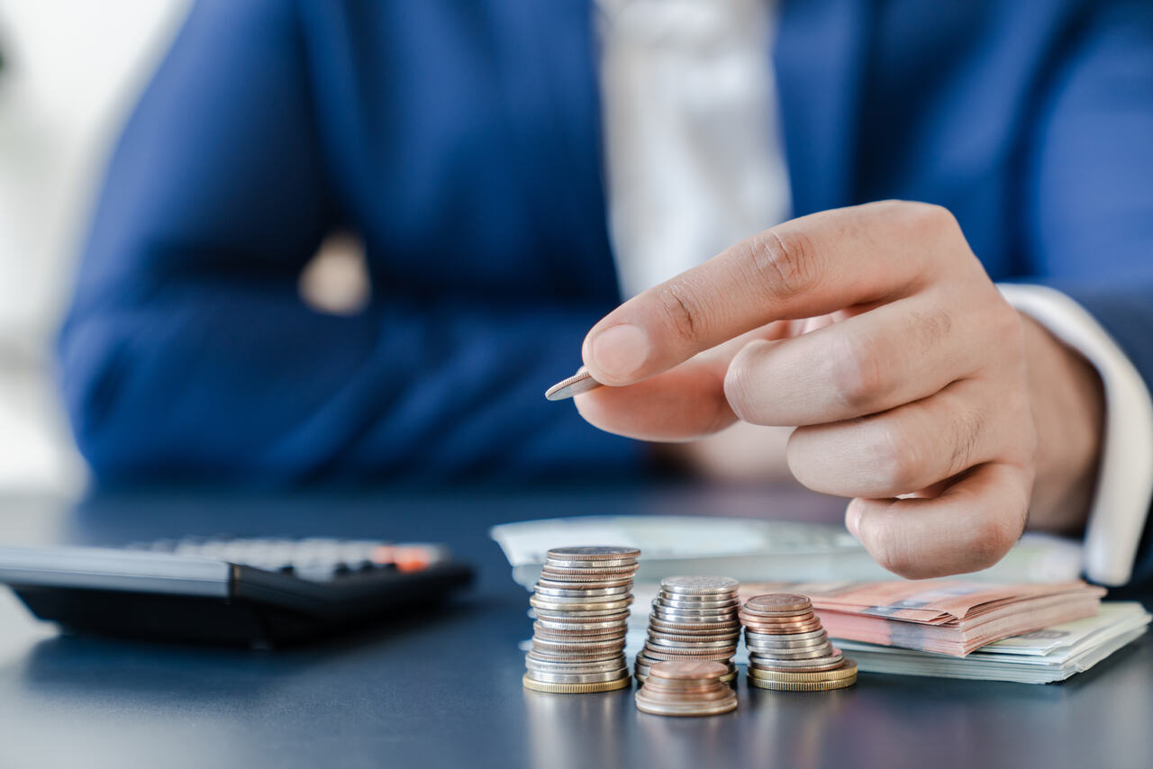Homem fazendo uma pilha de moedas para montar a reserva de contingência da empresa.