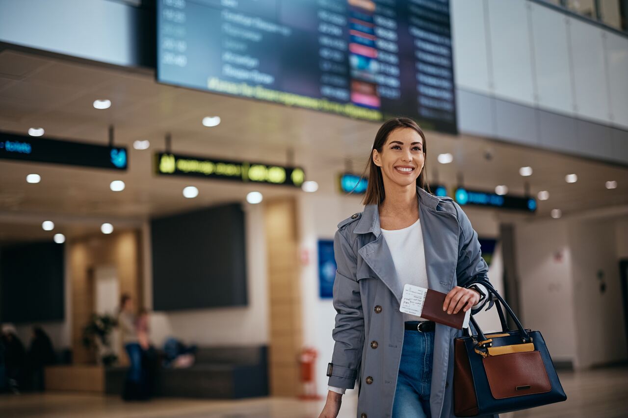 Mulher no aeroporto indo para uma viagem corporativa, a fim de falarmos sobre a taxa de embarque.